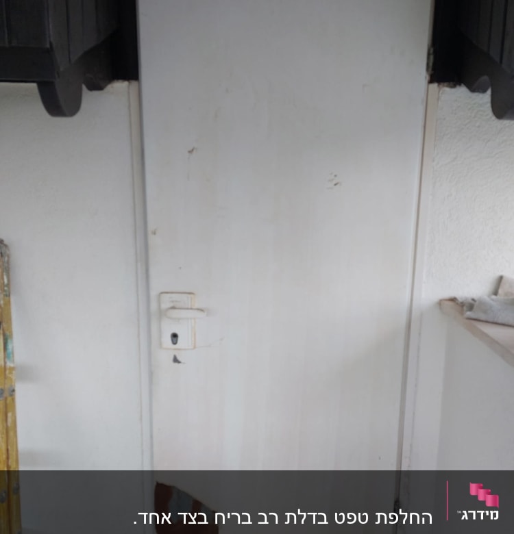 דלת לבנה עם קילופי צבע בתחתית